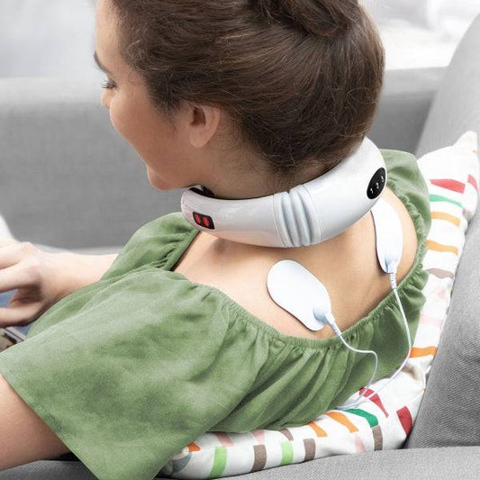 Femeie relaxându-se pe canapea folosind Aparat de Masaj pentru Gât și Spate Electromagnetic Calmagner Inovamarket cu electrozi aplicați pe spate.