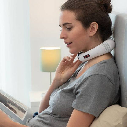 Utilizatoare citind în pat în timp ce folosește Aparatul de Masaj pentru Gât și Spate Electromagnetic Calmagner Inovamarket pentru relaxare.