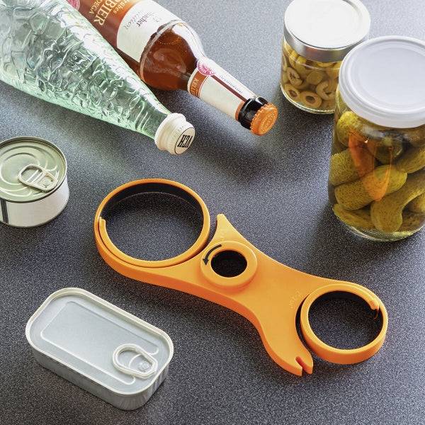 Desfăcător de Borcane Multifuncțional 5 în 1 Inovamarket portocaliu, așezat pe blat lângă conserve și sticle, perfect pentru deschiderea recipientelor diverse.