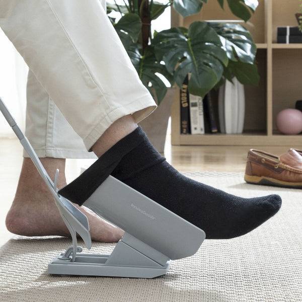 Persoană folosind Shoeasy Inovamarket pentru a încălța șosete, dispozitiv ergonomic 3-în-1 pentru confort zilnic