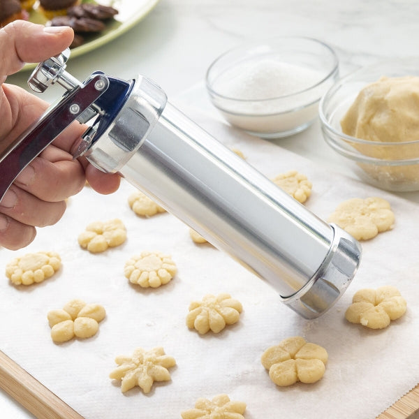 Dispozitivul Prekies Inovamarket presează aluatul pentru biscuiți în forme decorative direct pe hârtie de copt.