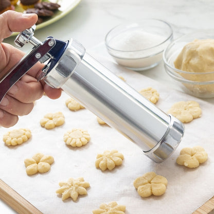 Dispozitivul Prekies Inovamarket presează aluatul pentru biscuiți în forme decorative direct pe hârtie de copt.